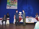 Maestro Enrique Deacon recibiendo el Trofeo de reconocimiento por parte del Representante de Bolivia